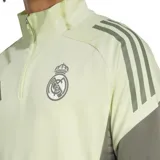 Buzo de entrenamiento Adidas del Real Madrid, color verde claro con mangas grises y detalles en gris oscuro. Presenta cuello alto con cierre de cremallera, logo de Adidas y escudo del Real Madrid en el pecho.
