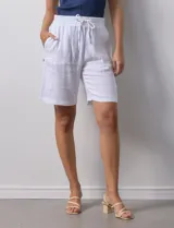 Bermuda blanca de algodón texturizado, marca Robert Louis. Tiene pretina ancha elastizada con lazo, bolsillos verticales delanteros y bolsillos laterales con botón.