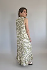 Vestido largo camisero sin mangas, con estampado de hojas en verde y blanco, cuello camisero y cierre frontal con botones.