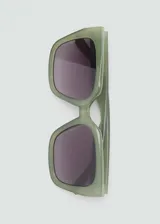 Lentes de sol cuadrados color verde oliva con lentes degradadas en gris. Fabricados con residuos post-industriales reciclados de procesos de fabricación de gafas de policarbonato.