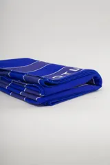 Toalla de playa de algodón con rayas verticales azules y blancas.