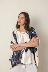 Blusa italiana color natural con estampado de hojas en tonos azules. De calce holgado y talle único.