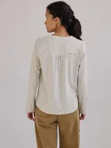 Remera color gris claro con cuello en V y volados de lino en el cuello.