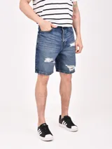 Bermuda de jean negro con roturas y corte a la rodilla.