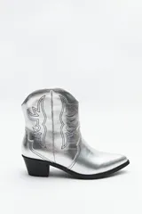 Botas texanas plateadas de caña baja con bordados negros a contratono y taco bajo.