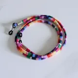Cuerda para lentes multicolor con terminales de goma negra y detalles metálicos plateados.