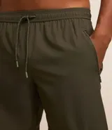 Bermuda deportiva negra sin estampado, con cintura elástica ajustable con cordón, y bolsillo lateral con cierre de cremallera contrastante.