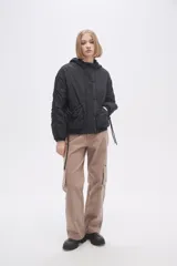 Campera negra de manga larga con capucha, cierre frontal con botones a presión, bolsillos laterales y cordón ajustable en la cintura.