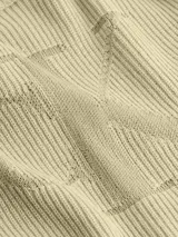 Sweater de punto color beige con cuello redondo y logo CK en el frente. Corte cropped y textura de canalé.
