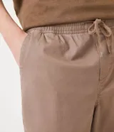 Pantalón jogger color marrón claro, con cintura elástica, cordón de ajuste y bolsillos laterales.