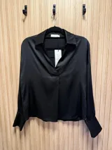 Blusa azul petróleo de seda con cuello clásico y corte asimétrico, más larga en la parte trasera.