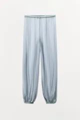 Pantalón celeste semitransparente de tiro medio con cintura elástica y tobillos abullonados con elástico.