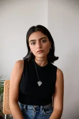 Collar con tiento encerado negro y dije dorado con forma de corazón texturizado.