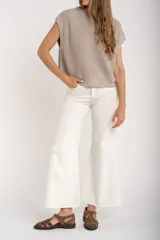 Chaleco de punto color beige con lurex, de corte recto y mangas cortas. Tejido calado con pequeños agujeros.