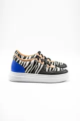Zapatilla acordonada con plataforma, de cuero vacuno con patrón de cebra y detalles en azul.