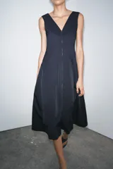 Vestido midi azul marino confeccionado en hilatura con algodón. Escote pico y tirantes anchos. Bajo evasé. Cierre frontal con cremallera metálica.