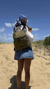 Mochila urbana de diseño compacto, color violeta/malva, con acabado ligeramente brillante. Presenta un compartimento principal con doble cierre superior y bolsillos laterales con cierre.