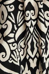Vestido midi con breteles spaghetti y estampado abstracto en blanco y negro.