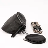 Riñonera negra de cuero con correa de tela estampada y monedero redondo con cierre.