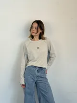 Remera manga larga color gris claro, de jersey 100% algodón, con corte holgado, mangas relaxed, largo a la cadera, bordado con logo en el frente y pespuntes en contraste.