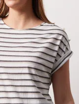 Blusa de Catherine Malandrino con estampado a rayas horizontales en blanco y gris, con apliques de botones dorados en los hombros y mangas cortas con dobladillo.