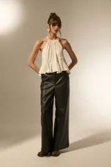 Pantalón ancho de tiro alto, confeccionado en eco-cuero negro.