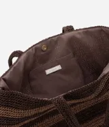 Bolso de playa tipo tote, confeccionado en paja color marrón con rayas horizontales negras.