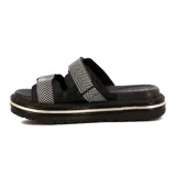 Sandalias de plataforma negras con dos tiras anchas ajustables. Las tiras tienen un patrón de espiga en blanco y negro. La suela es gruesa y dentada, con una línea decorativa dorada en el borde.