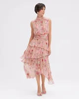 Vestido midi sin mangas con estampado floral, cuello alto, frunces en la cintura y falda escalonada de gasa. Espalda abierta con cierre de botón en el cuello y cremallera invisible.