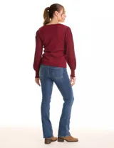 Buzo de tejido lurex marca Nanette en color bordó, con cuello a la base y mangas largas de diseño plisado. Los puños cuentan con apliques de botones decorativos.