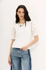 Remera blanca de algodón con calce al cuerpo, cuello redondo y tajos laterales. Mangas balloon con bordado tipo broderie.