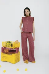 Pantalón de jean acampanado azul con bolsillos delanteros con detalle de volados.