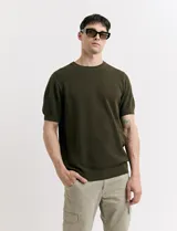 Remera de tejido de punto color verde militar, de manga corta y cuello redondo.