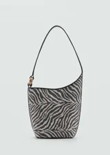 Bolso tipo bucket con estampado de cebra, asa corta y cierre de botón magnético.