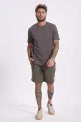 Remera de manga corta color gris oscuro, con cuello redondo y un bolsillo pequeño en el pecho.