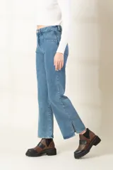 Pantalón de jean azul claro, corte bootcut, con bolsillos delanteros y traseros, y aberturas laterales en el ruedo.