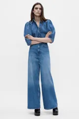 Blusa de denim con cuello solapa y manga abullonada por debajo del codo. Cierre frontal con botones.