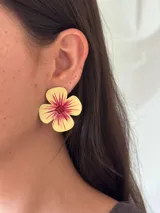 Aro de flor pintado a mano, con pétalos amarillos y centro rojo/fucsia con vetas. Presenta detalles brillantes y mostacillas en el centro.