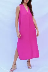 Vestido largo fucsia con escote en V y tajos laterales.