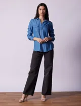 Camisa celeste de lyocell, marca Zac & Rachel. Cuello con solapa, abertura central con botones y bolsillos delanteros.