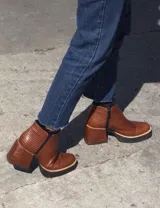 Botas cortas negras con textura de piel de serpiente y detalles en charol.