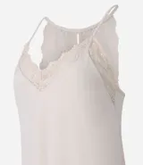 Conjunto de pijama short doll color crema, compuesto por un top de breteles finos con escote en V y detalles de encaje, y un short con cintura elástica y detalles de encaje en los laterales.