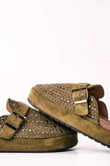 Zuecos de gamuza color verde militar con plataforma y hebilla ajustable. Decorados con tachas plateadas.