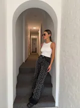 Pantalón de jean negro con tachas plateadas en forma de corazón.