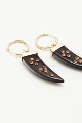 Aros colgantes dorados con forma de argolla pequeña y dije en forma de cuerno de resina con incrustaciones de strass.