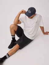 Gorra de lona lavada color azul con visera curva y parche bordado con el logo de Rusty en el frente.