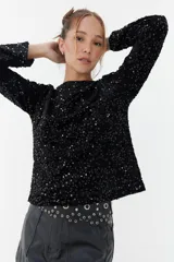Sweater negro de lentejuelas con cuello redondo y mangas largas.