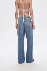 Pantalón de jean azul de tiro alto, corte recto y aberturas laterales en el ruedo.