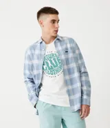 Camisa de franela celeste con estampado de cuadros blancos, corte regular, cuello camisero, mangas largas, abotonada frontal, bolsillo en el pecho y logo de la marca en etiqueta sobre el bolsillo.