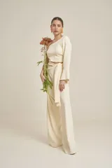 Top color crema de corte cropped, con un solo hombro y manga larga acampanada.